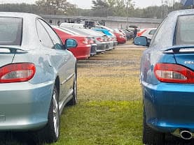 Arrières de 406 Coupé alignées sur l'herbe par temps couvert