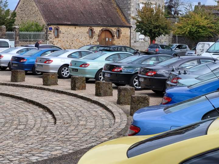 406 Coupé grises, noires et bleues garées devant une chapelle en pierre