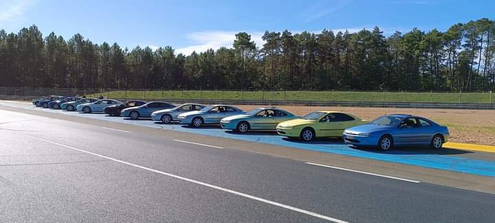 Lignée de 406 Coupé multicolores stationnées en bord de circuit